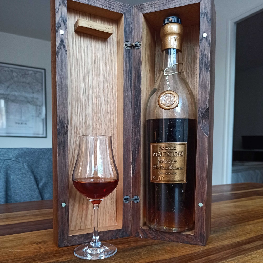 Mauxion Sélection Multimillésimes Cognac in wooden box next to glass filled with cognac