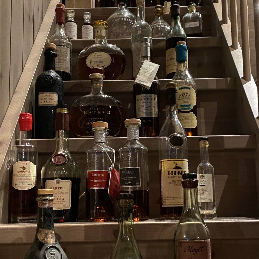 different cognac bottles on a stair case